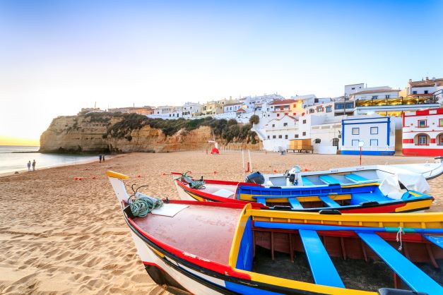 Idyllic beach scene, colorful row boats along shore, Portimão, Portugal. 