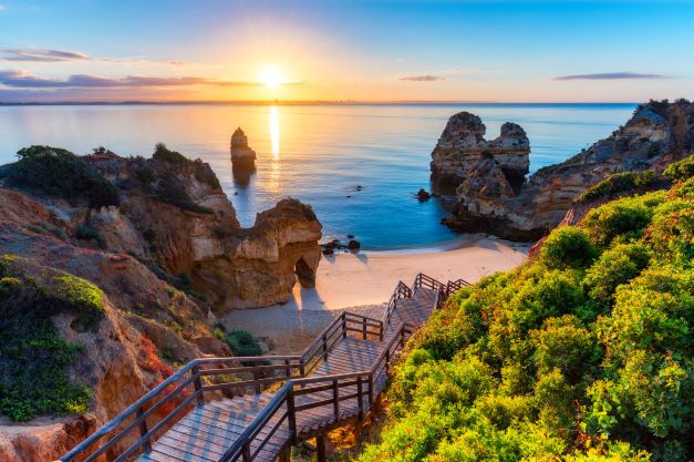 Stunning image, wood walkway down to beach from cliff, sunset, the Algarve, Portugal.