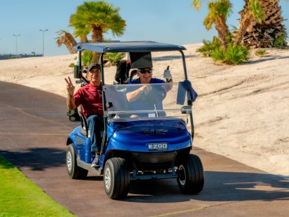 Two men wave from a golf cart at Viva! Las Vegas Pro-Am in Las Vegas