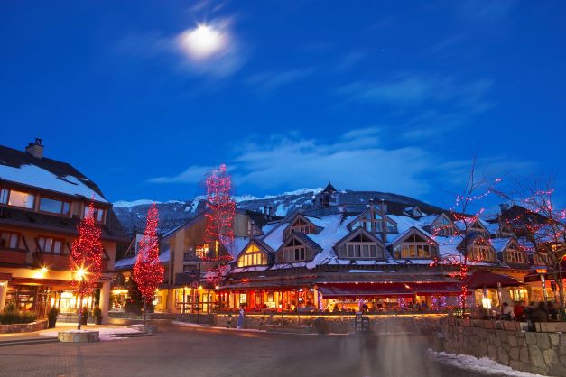Whistler, Canada, main street, glowing, snow-capped mountains in the distance. 