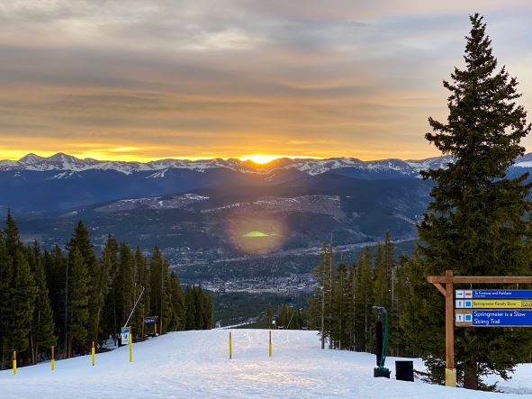 Morning sun rising through evergreen-lined ski slope, Breckenridge, Colorado. 