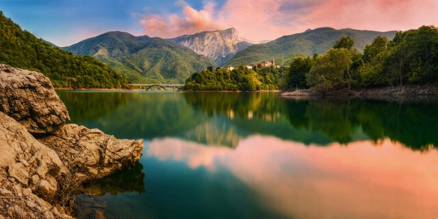 Serene lake vista with mountains and sunset skies, Italy.