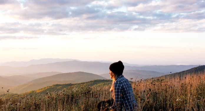 Woman sitting atop a mountain peak and enjoying the peaceful view, Great Smoky Mountains National Park. 