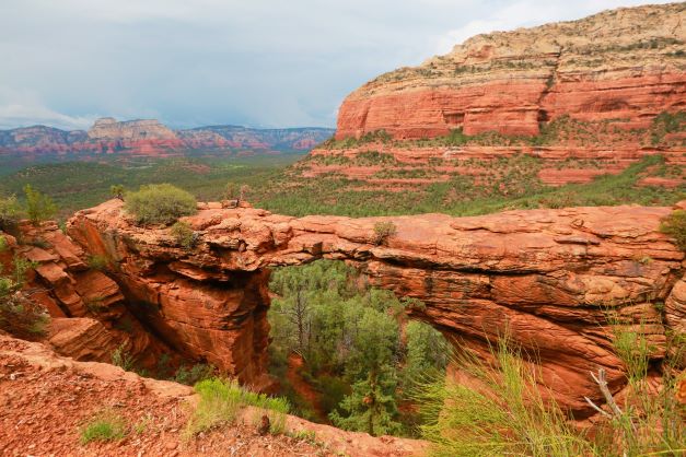 View of Devil's Bridge in Sedona, Arizona, a red sandstone rock feature in the desert.