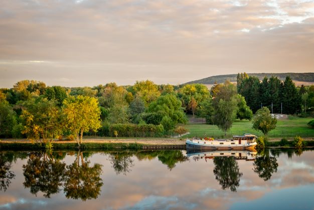 Picturesque panorma of a canal boat in the french countryside, France. 