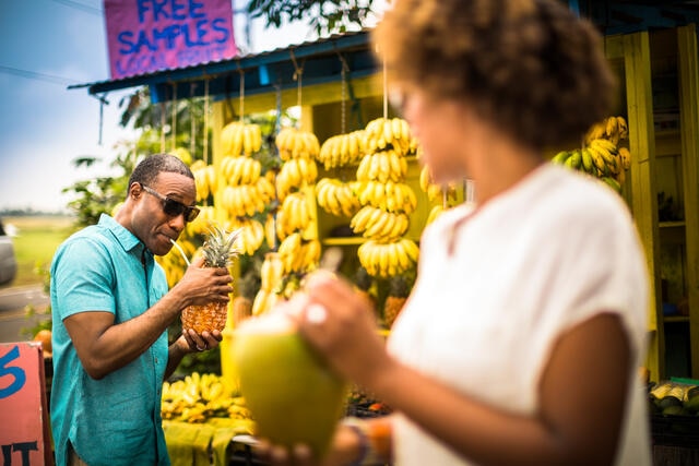 Couple buying goods and being plaful at local fruit stand, Big Island, Hawaii. 