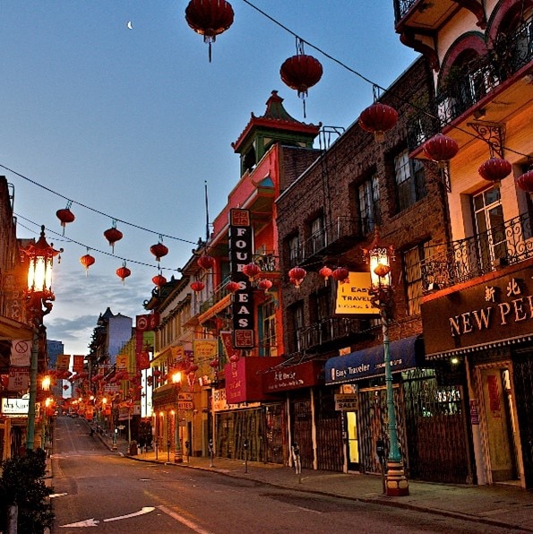 Chinese lanterns hanging overhead a Chinatown street at dusk, San Francisco, California.