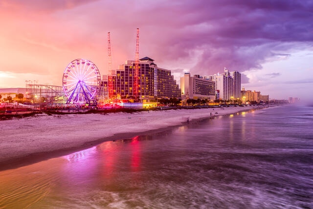 Stunning aerial view of Daytona Beach Boardwalk glowing against the dusk sky, Florida. 