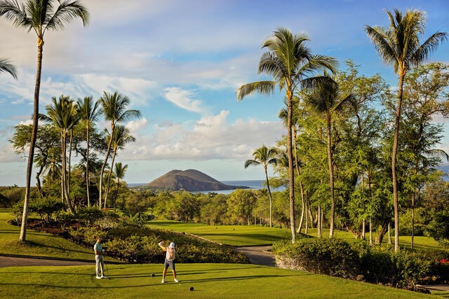 Stunning aerial image, two men playing golf, picturesque oceanside golf course, mountains in the distance, Grand Wailea Maui, a Waldorf Astoria Resort, Hawaii. 