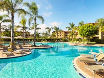 Palm trees and pool on a sunny day at MarBrisa, a Hilton Grand Vacations Club, in Carlsbad, California
