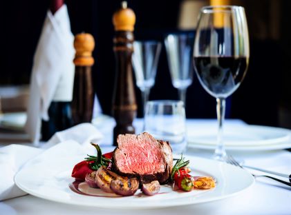 A plate of steak and glass of wine at a fine dining restaurant