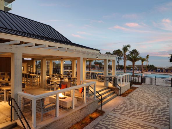 Outdoor dining area near the pool and beach at Ocean Oak Resort, a Hilton Grand Vacations Club, in Hilton Head Island, South Carolina