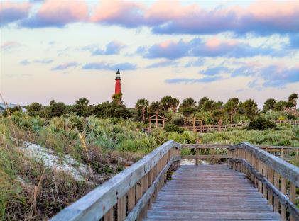 A boardwalk in Ormond Beach in view of the Ponce de Leon inlet lighthouse in Florida