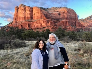 Explorer Bruce G. and his wife posing in front of the red rock formations in Sedona, Arizona