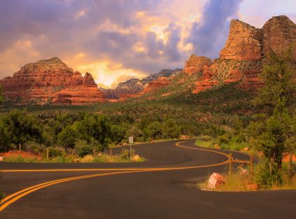 A road winding through the red rock formations in Sedona, Arizona, at sun rise