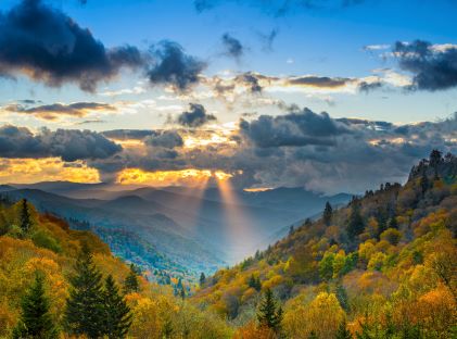 Sun rays through clouds over an autumnal view of the Great Smoky Mountains National Park