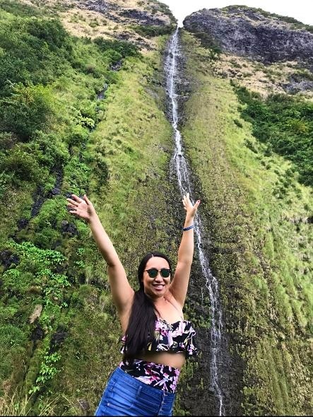 Hilton Grand Vacations Owner posing, picturesque waterfall, Maui, Hawaii.