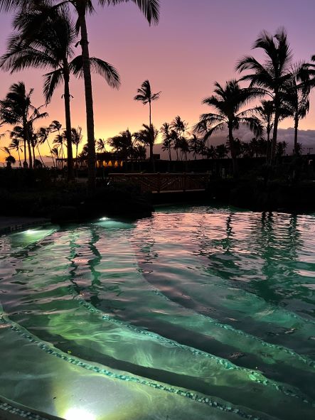 Hilton Grand Vacations Owner's beautiful poolside image, sunset painted skies, palm tree silhouettes, Maui Bay Villas, a Hilton Grand Vacations Club, Hawaii. 