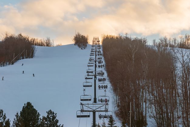 Ski lift going up snow-covered mountain, The Blue Mountains, Ontario, Canada. 