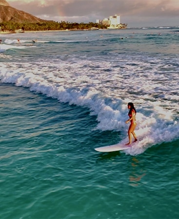 Hilton Grand Vacations Owner Raeanne surfing while on vacation in Hawaii