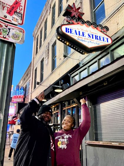 A Hilton Grand Vacations Owner poses at the Beale Street sign in Memphis, Tennessee