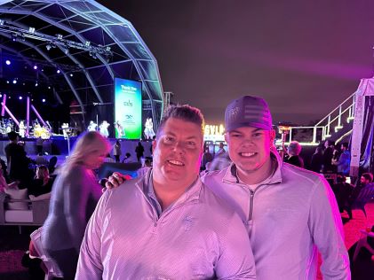 A Hilton Grand Vacations Owner and his son at a concert at the 2023 Hilton Grand Vacations Tournament of Champions