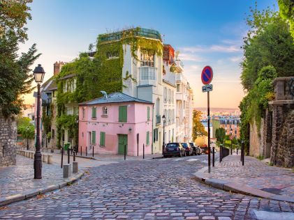 Colored buildings and cobblestone streets in Montmarte, a neighborhood in Paris, France at sunset