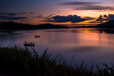 Mountain lake, dusk, purple painted skies overhead fisherman silhouettes, Gatlinburg, Tennessee. 