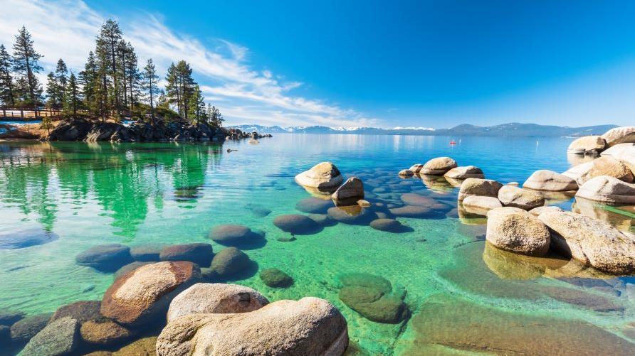 Crystal clear waters, blue skies, alpine-lined shore, Emerald Bay, Lake Tahoe, California. 