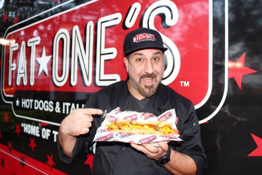 Joey Fatone points to a hot dog from his food truck, Fat Ones