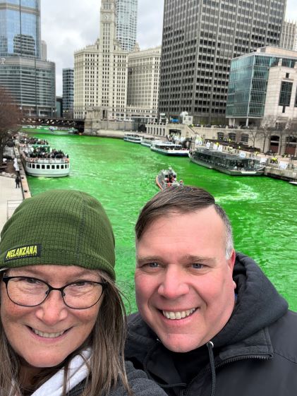 Two Hilton Grand Vacations Owners pose for a selfie by the Chicago River, dyed green for St. Patrick's Day