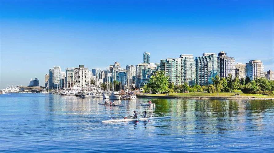 Kayaks on a sunny day with the Vancouver skyline