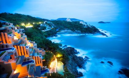 Cliffside villas, ocean view, crashing waves, dusk colored sky, Zihuatanejo, Mexico. 