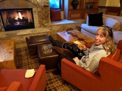 Hilton Grand Vacations Owner, sitting by fireplace, Colorado vacation, Valdoro Mountain Lodge, a Hilton Grand Vacations Club, Breckenridge, Colorado. 
