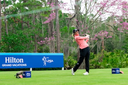 An LPGA golfer swings a golf club from a tee box at the Hilton Grand Vacations Tournament of Champions