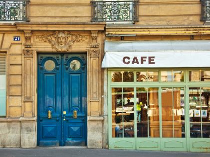 A blue door and awning labeled "Cafe" in Paris