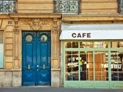 A blue door and awning labeled "Cafe" in Paris