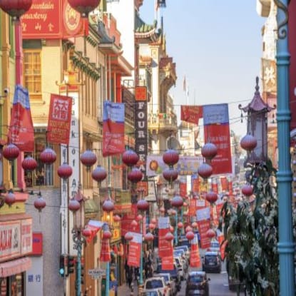 Chinese lanterns hanging overhead a Chinatown street at dusk, San Francisco, California.