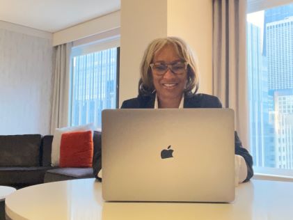 A Hilton Grand Vacations Member at her laptop in her Suite at Chicago Magnificent Mile, a Hilton Grand Vacations Club