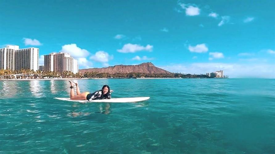 A Hilton Grand Vacations Member surfs in Oahu, Hawaii