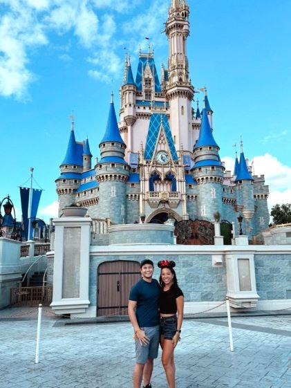 A Hilton Grand Vacations Member posing in front of Cinderella's Castle at Walt Disney World theme park in Orlando