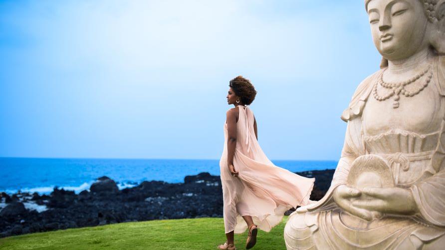 Relaxing image, woman gazing out to sea, lava rock-lined shoreline, clear blue skies, Buddha Point, Ocean Tower, a Hilton Grand Vacations Club, Big Island, Hawaii 