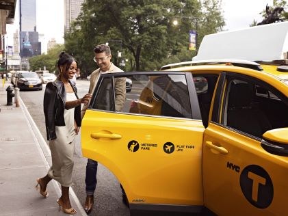 A man and a woman enter a yellow taxi before a night on the town in New York City