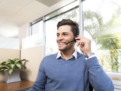 A Hilton Grand Vacations Team Member on the phone helping a Member