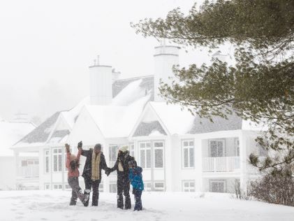 A family plays in the snow at Tremblant, a Hilton Grand Vacations Club in Quebec, Canada