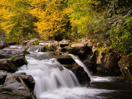 Waterfall through autumnal forest on the Nantahala River near Sapphire, North Carolina