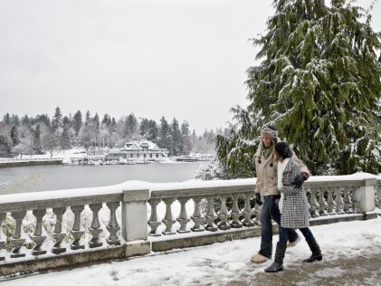 Couple walking over a bridge on a snowy day in Vancouver, Canada
