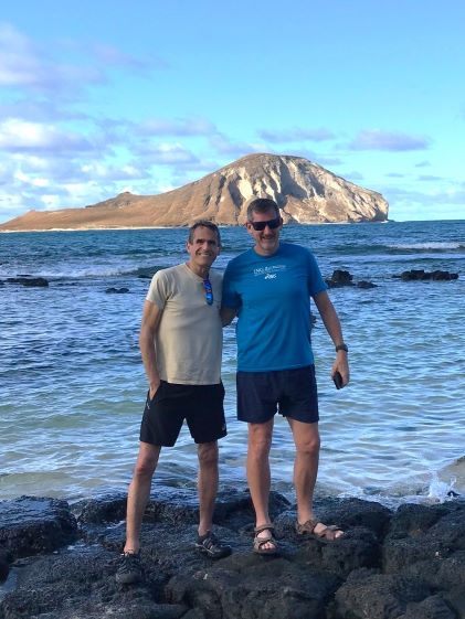 Two older brother posing while on vacation in Hawaii, thanks to Hilton Grand Vacations