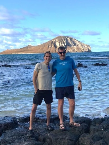 Two older brother posing while on vacation in Hawaii, thanks to Hilton Grand Vacations