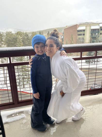 A Hilton Grand Vacations Member and her son posing on the balcony of their Suite at Valdoro Mountain Lodge, a Hilton Grand Vacations Club in Breckenridge, Colorado